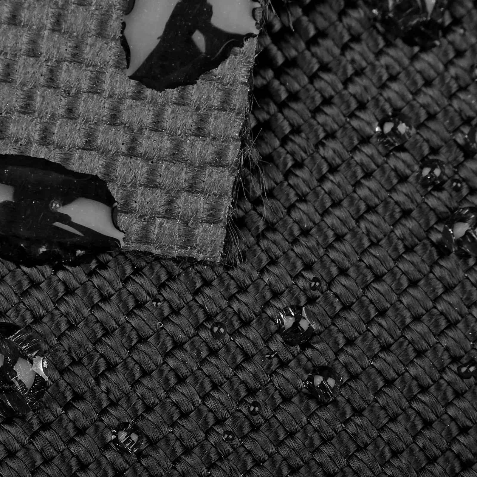 Water droplets resting on the surface of black woven fabric